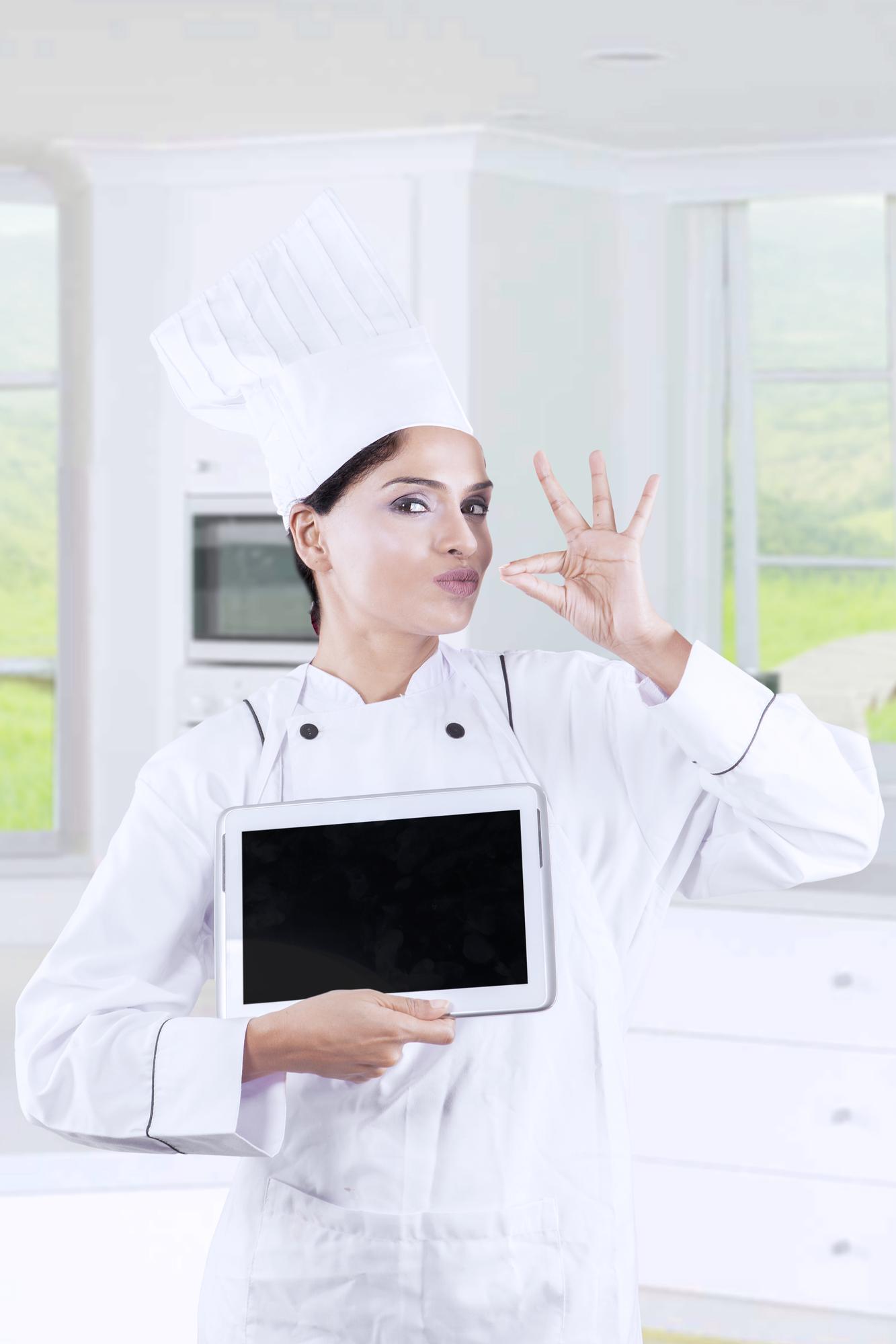 Chef enseñando desde una cocina moderna con pantalla